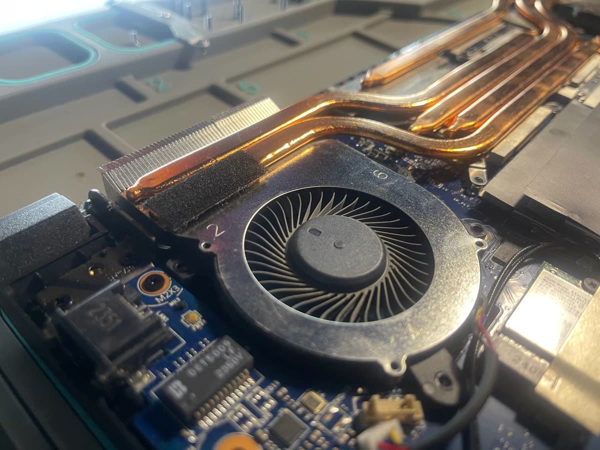 Gamer laptop ventilátora közelről: a lapátok tiszták, a por a hűtőbordán ül
