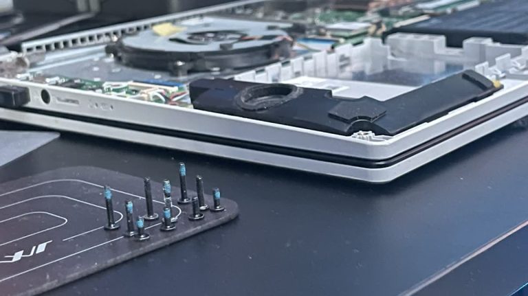 Laptop belső tisztítása: poros hűtőborda és ventilátor a szétszerelt gépben