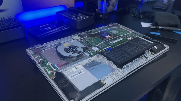 Szétszerelt laptop alsó fedéllel, látható memóriamodul és akkumulátor bővítés előtt