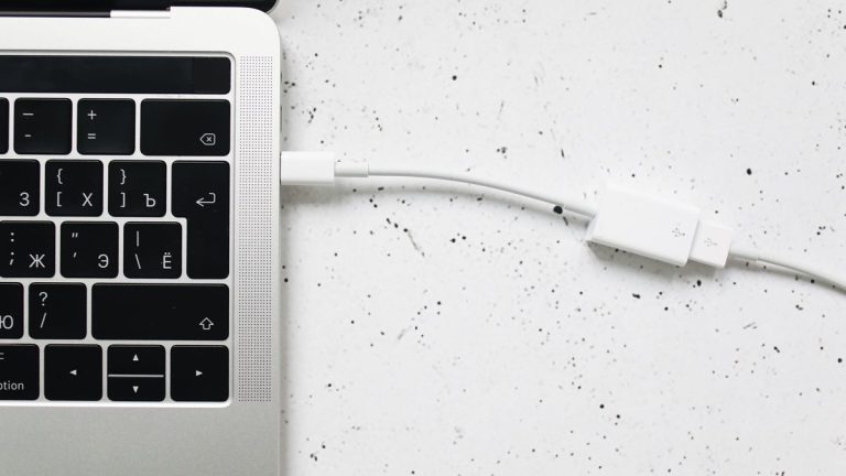 Laptop oldalába dugott töltőkábel közelről